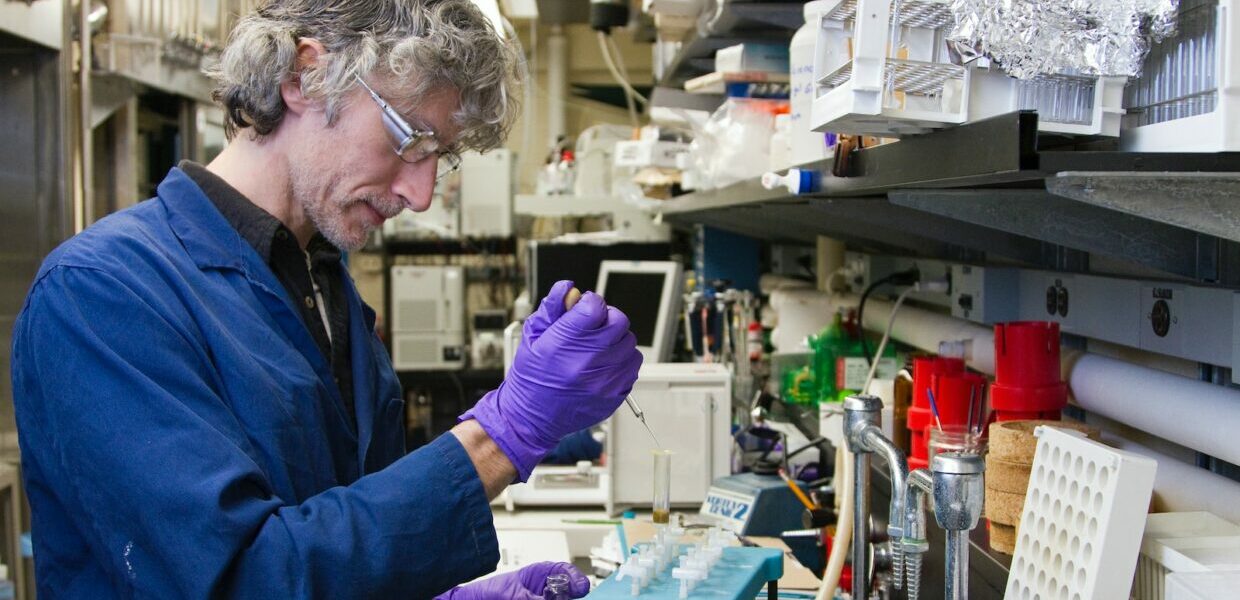 woman dropping a specimen on a test tube