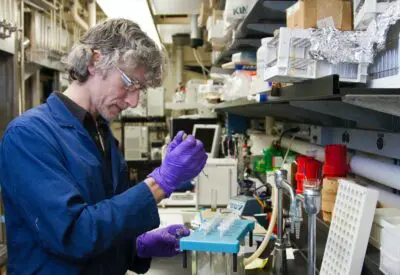 woman dropping a specimen on a test tube