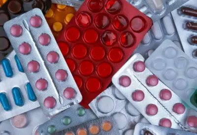pile of blister packs of colorful medicine tablets