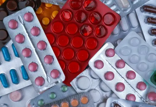 pile of blister packs of colorful medicine tablets