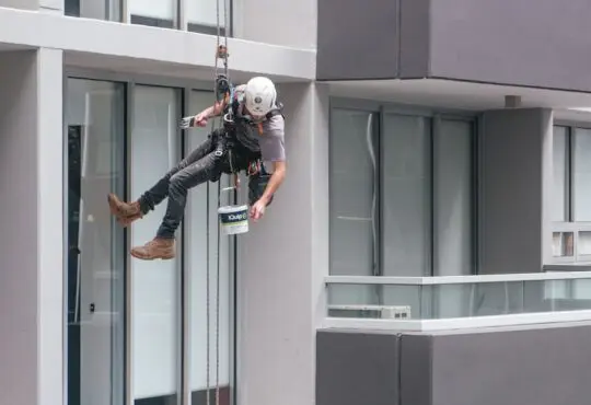 man in black jacket and black pants jumping on window during daytime