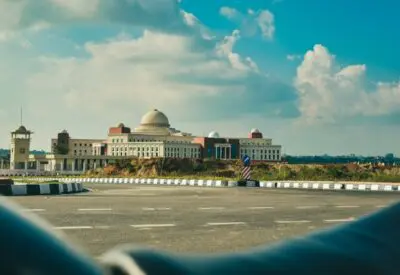 white and brown concrete building under white clouds and blue sky during daytime