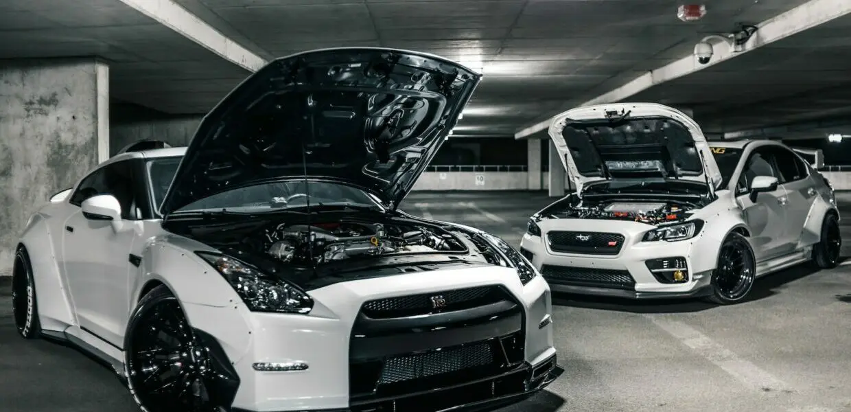 two white cars with open hoods